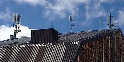 Die Antennen im Juli 2015: links Wind mit GSM und UMTS, in der Mitte die Stabantenne von Tim für GSM und rechts die 2 Antennen für GSM von Vodafone.
